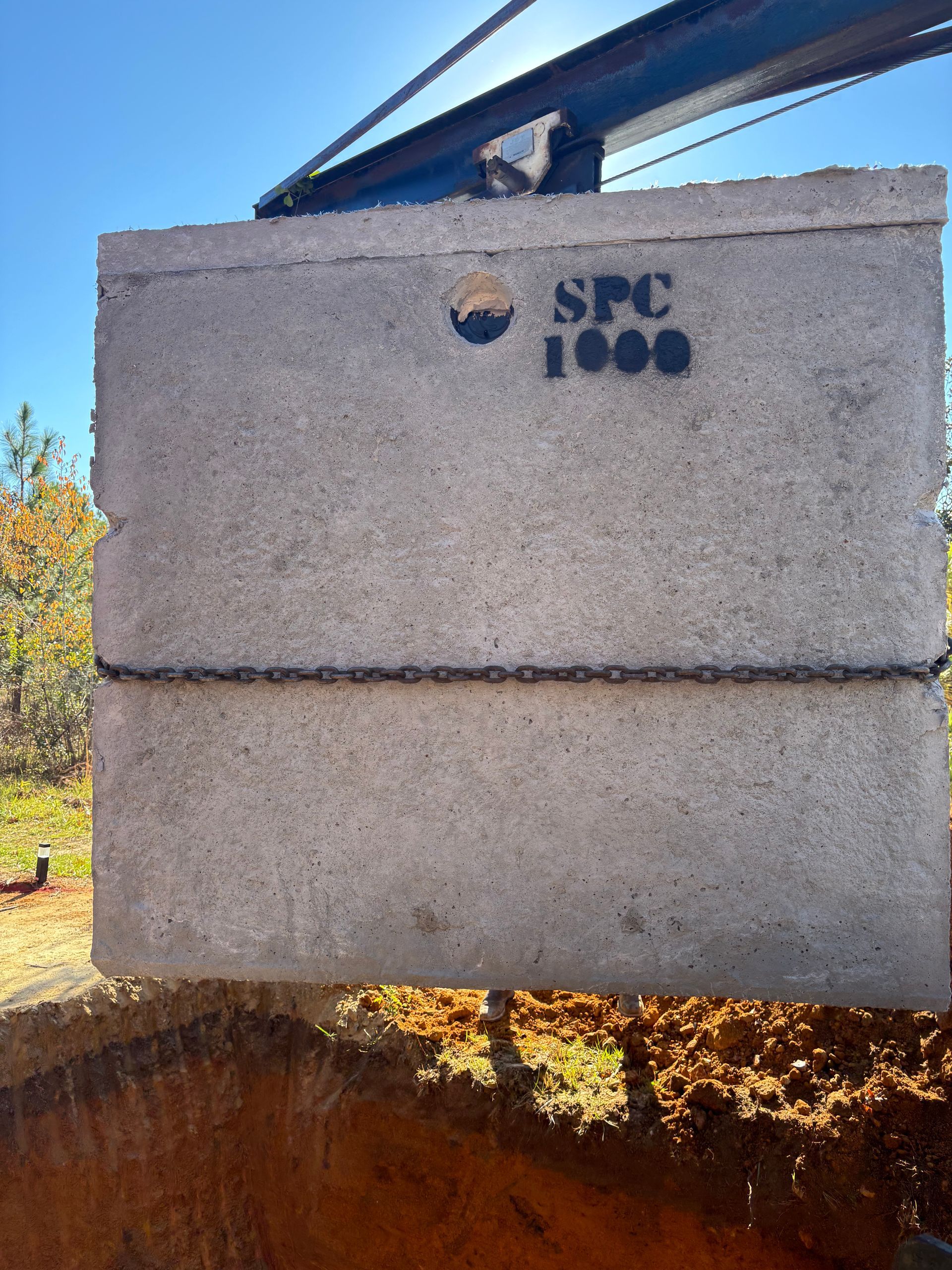 Concrete wall with “SPC 1000” logo, outdoors under a blue roof
