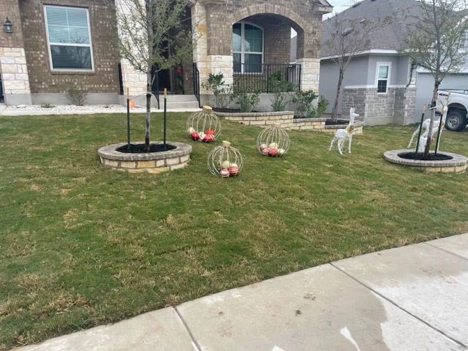 Lawn with white lawn figurines, a black dog statue, and a stone house front yard with sidewalks