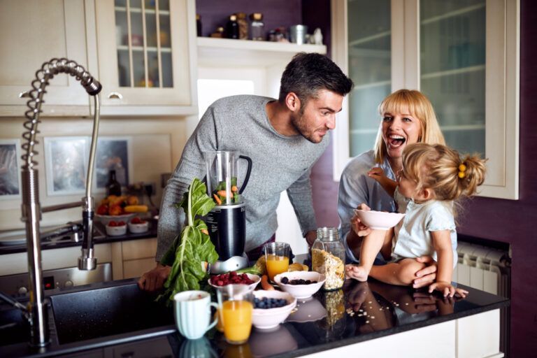 A family is sitting at a kitchen counter preparing food.