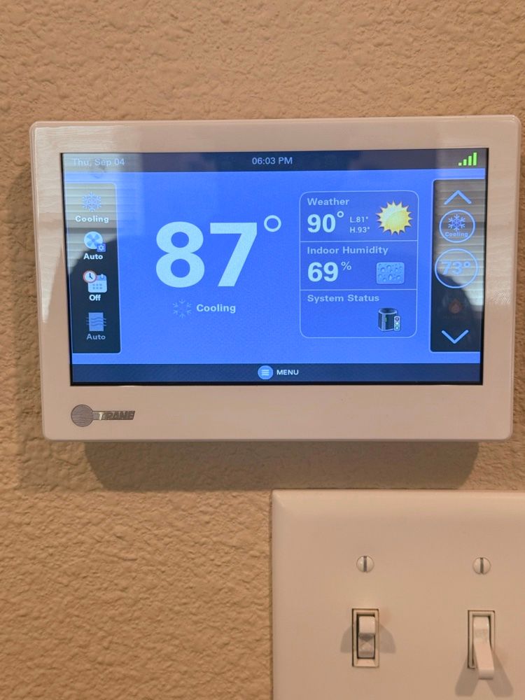 Hands installing a white ceiling air filter in a vent opening