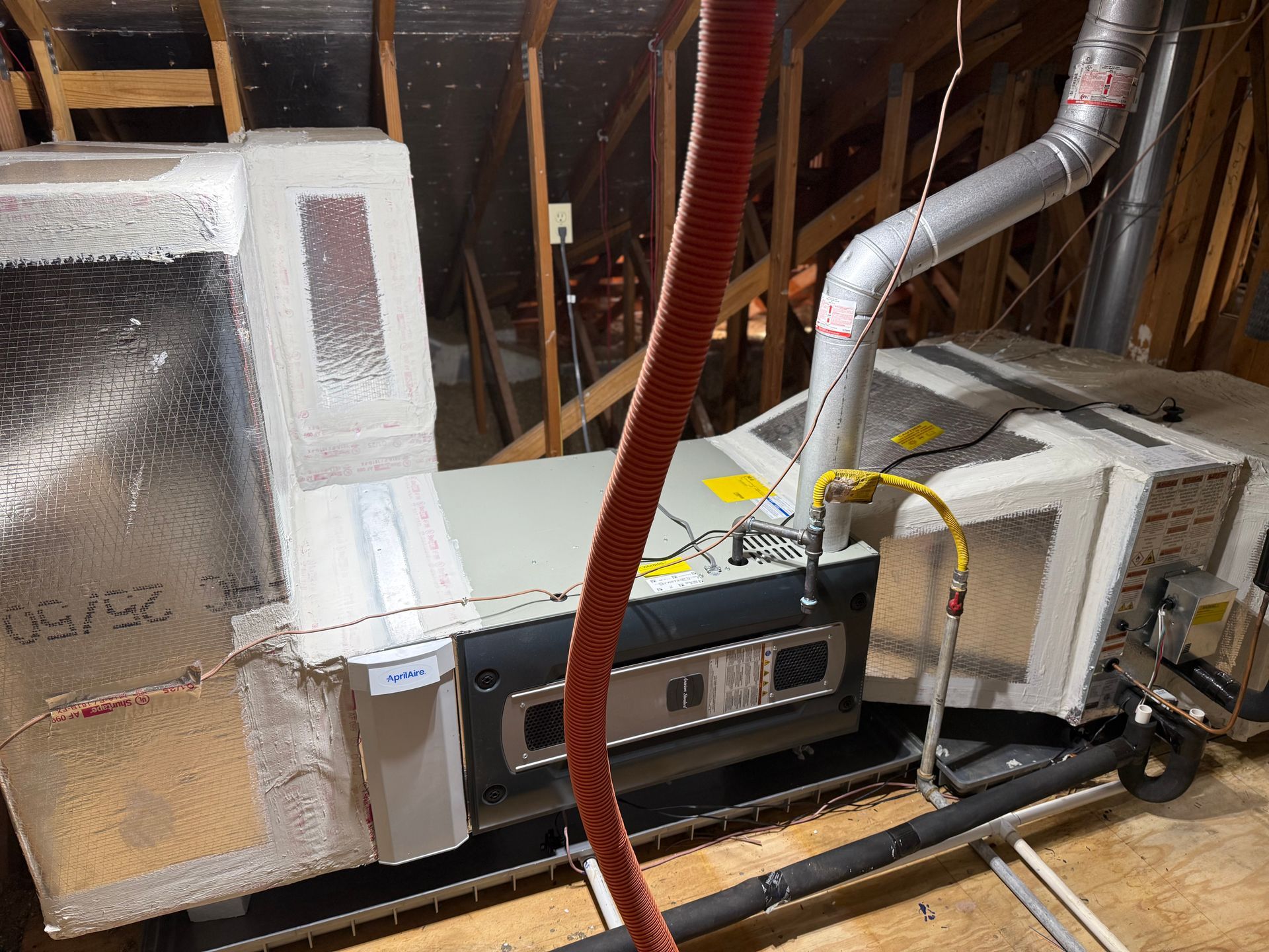 Technician using gauges to service an outdoor air-conditioning unit