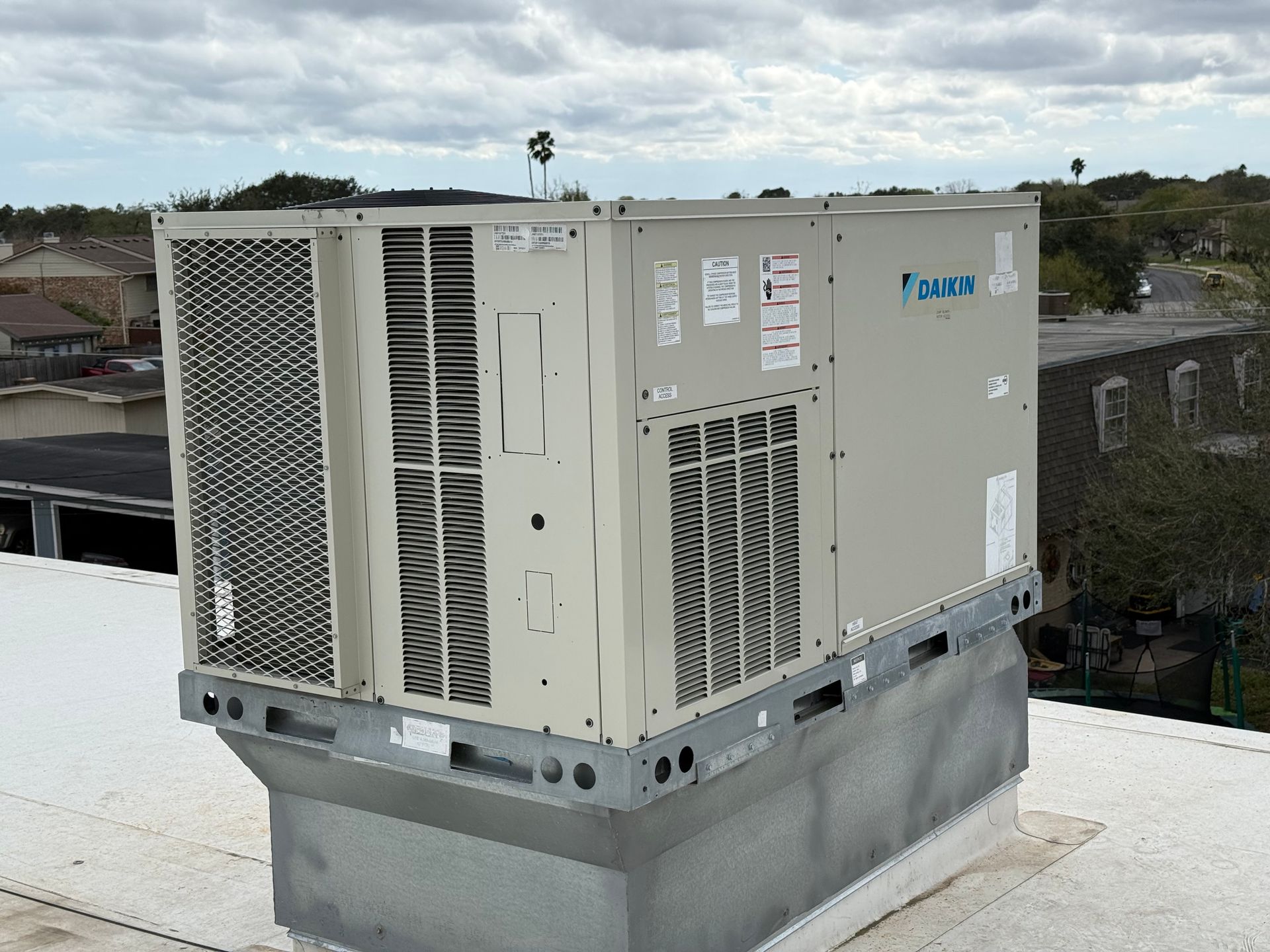 Technician holding gauges and giving a thumbs-up beside an outdoor air conditioning unit