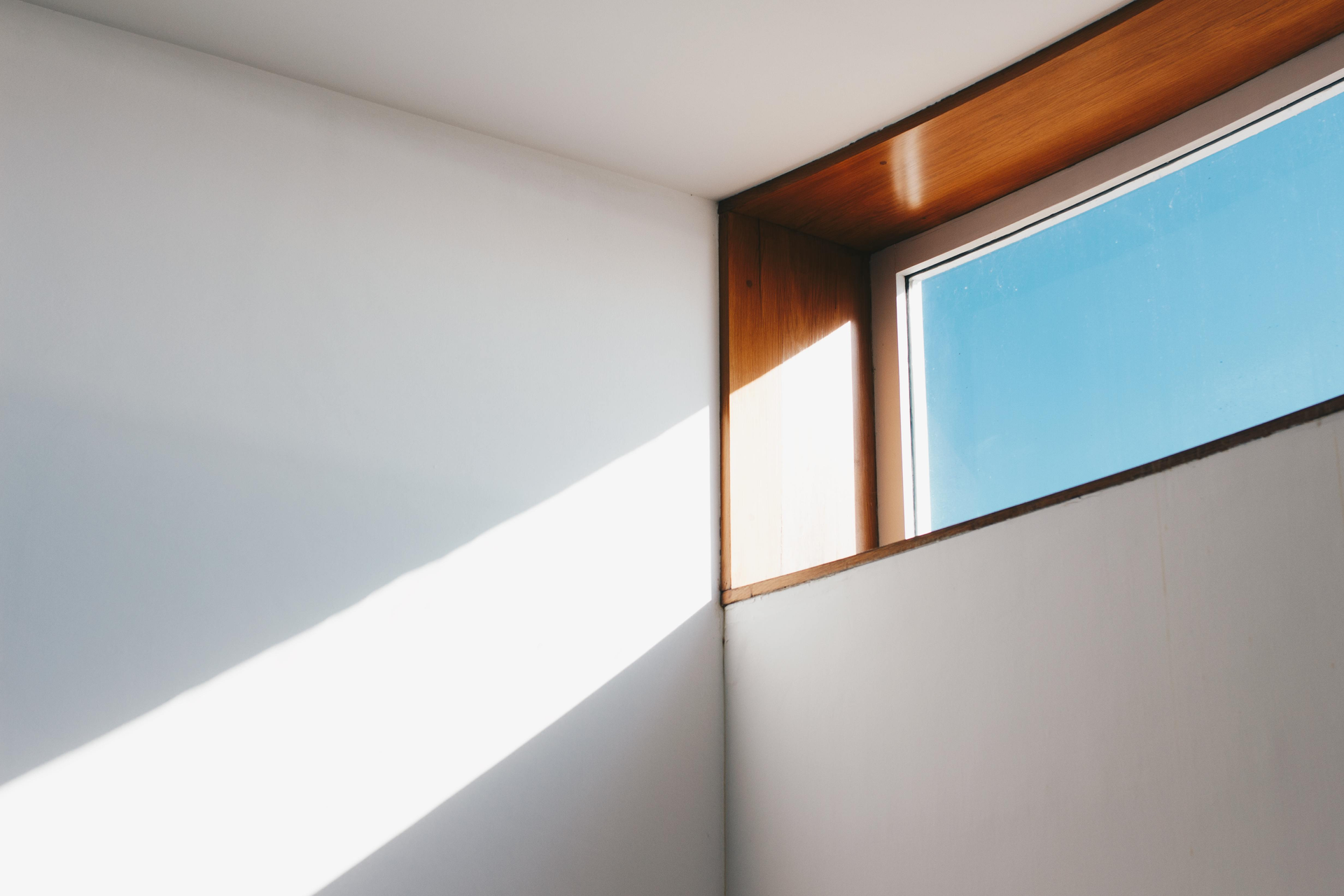 The sun is shining through the window and casting a shadow on the wall.