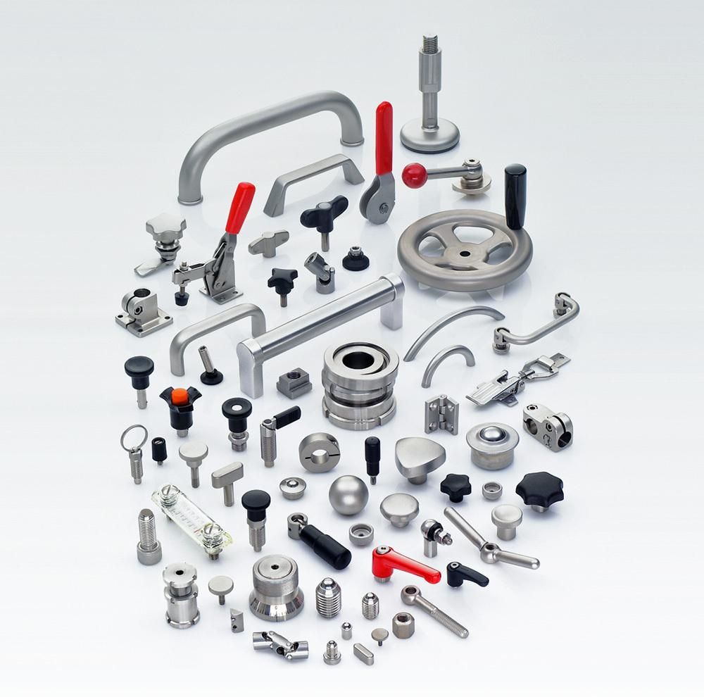 Assorted metal hardware parts, bolts, knobs, and fittings arranged on a white background