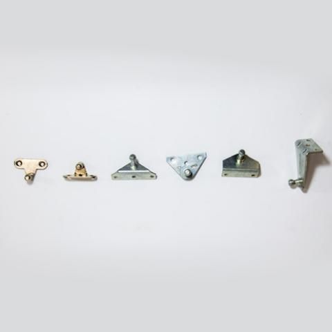 Six small metal brackets and hinges arranged in a row on a white background