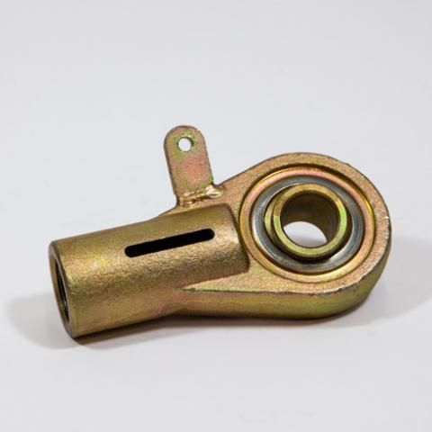 Brass-colored mechanical bearing housing with a circular hole and mounting tab on a white background