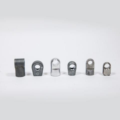 Six small metal fasteners arranged in a row on a light gray background