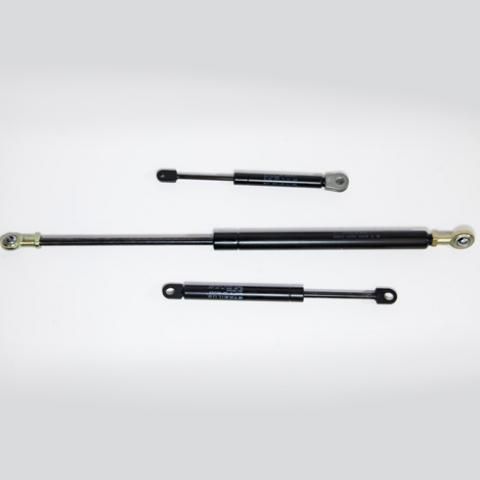 Three black gas struts of different lengths on a white background