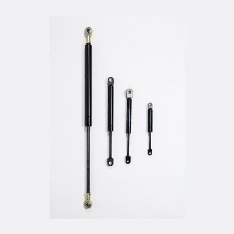 Four black gas struts of different lengths on a white background