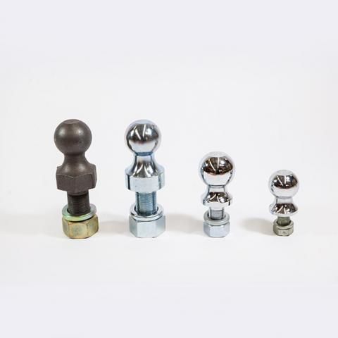 Four metallic trailer hitch balls of different sizes arranged in a row on a white background