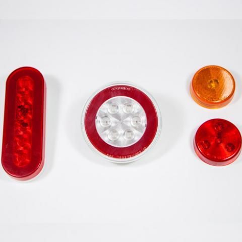 Red, clear, and orange round and oval plastic pieces arranged on a white background