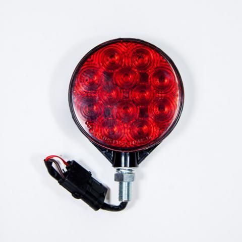 Red round LED light with black mounting bracket and attached wires on a white background