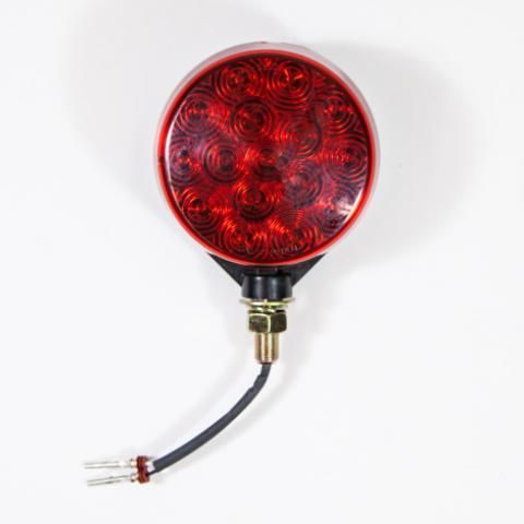 Round red LED light with a black wire and brass connector on a white background