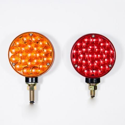 Two round LED signal lights, one orange and one red, on a white background