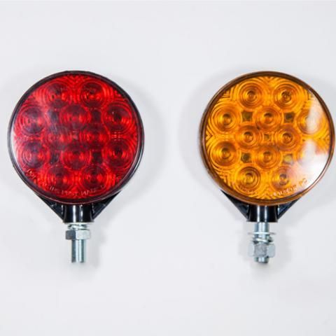 Two round LED signal lights, one red and one amber, on a white background