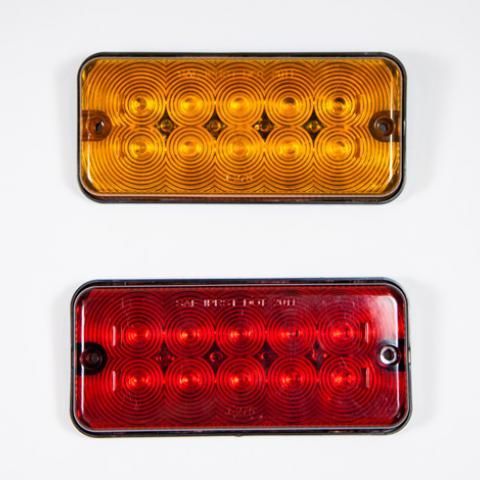 Two rectangular vehicle lights, amber on top and red on bottom, with concentric circular lenses.