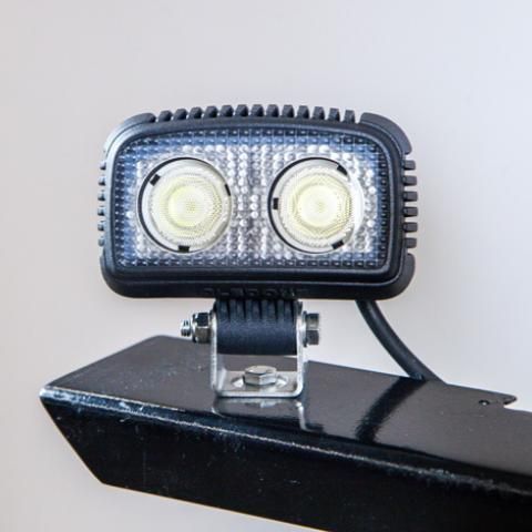 Black rectangular LED work light with two round bulbs mounted on a bracket