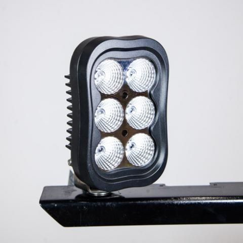Black rectangular LED work light with six bright bulbs mounted on a metal bracket