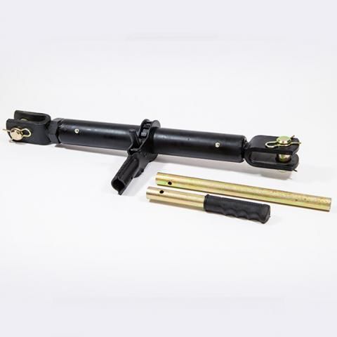 Black metal tensioning tool with brass ends and two gold rods on a white background