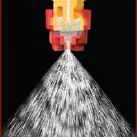 Red fire nozzle spraying a wide white stream against a black background