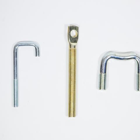 Three metal fasteners: two silver bent rods and one gold threaded bolt on a white background