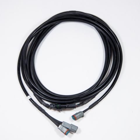 Coiled black cable with gray connectors on a white background