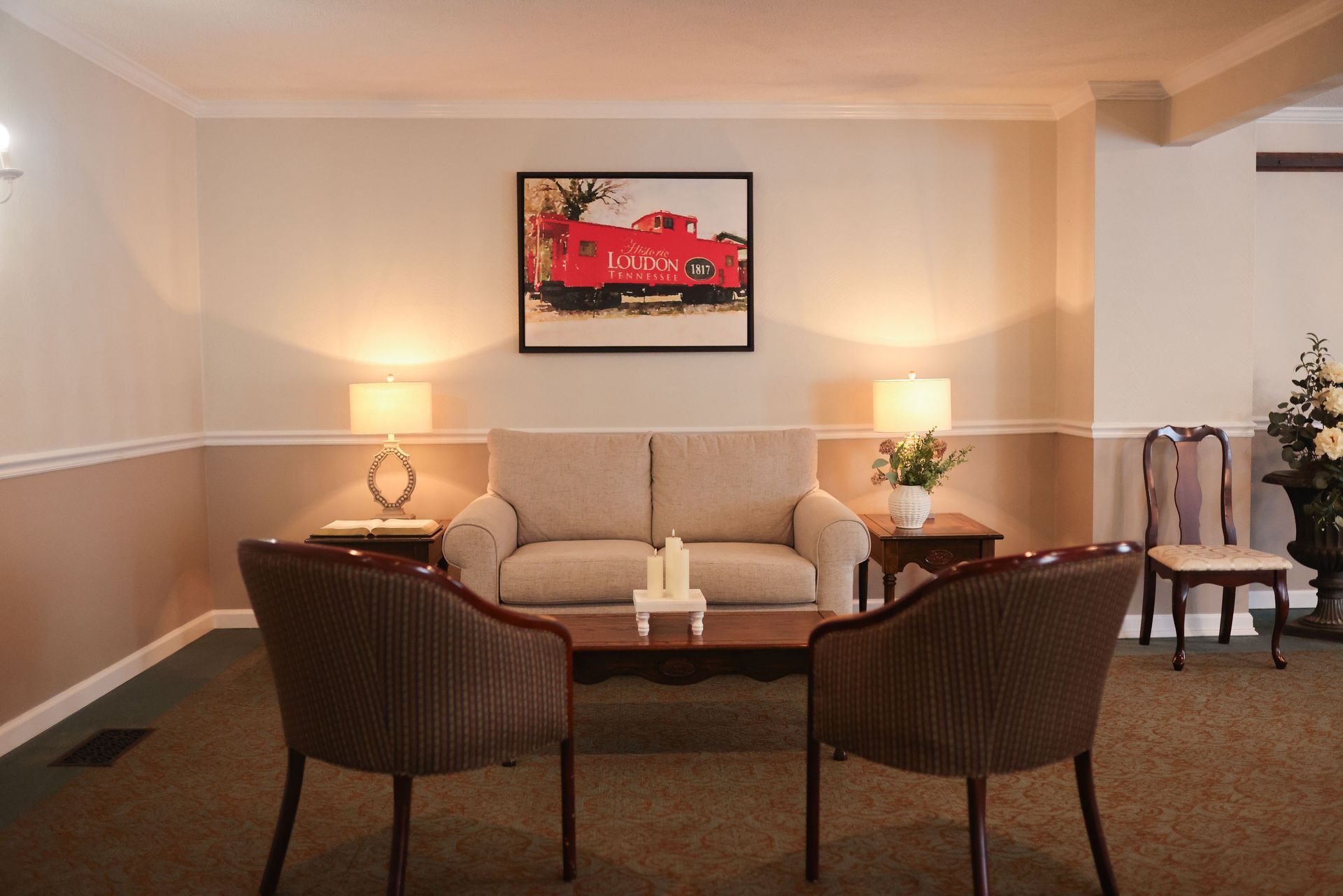 A living room with a couch and two chairs