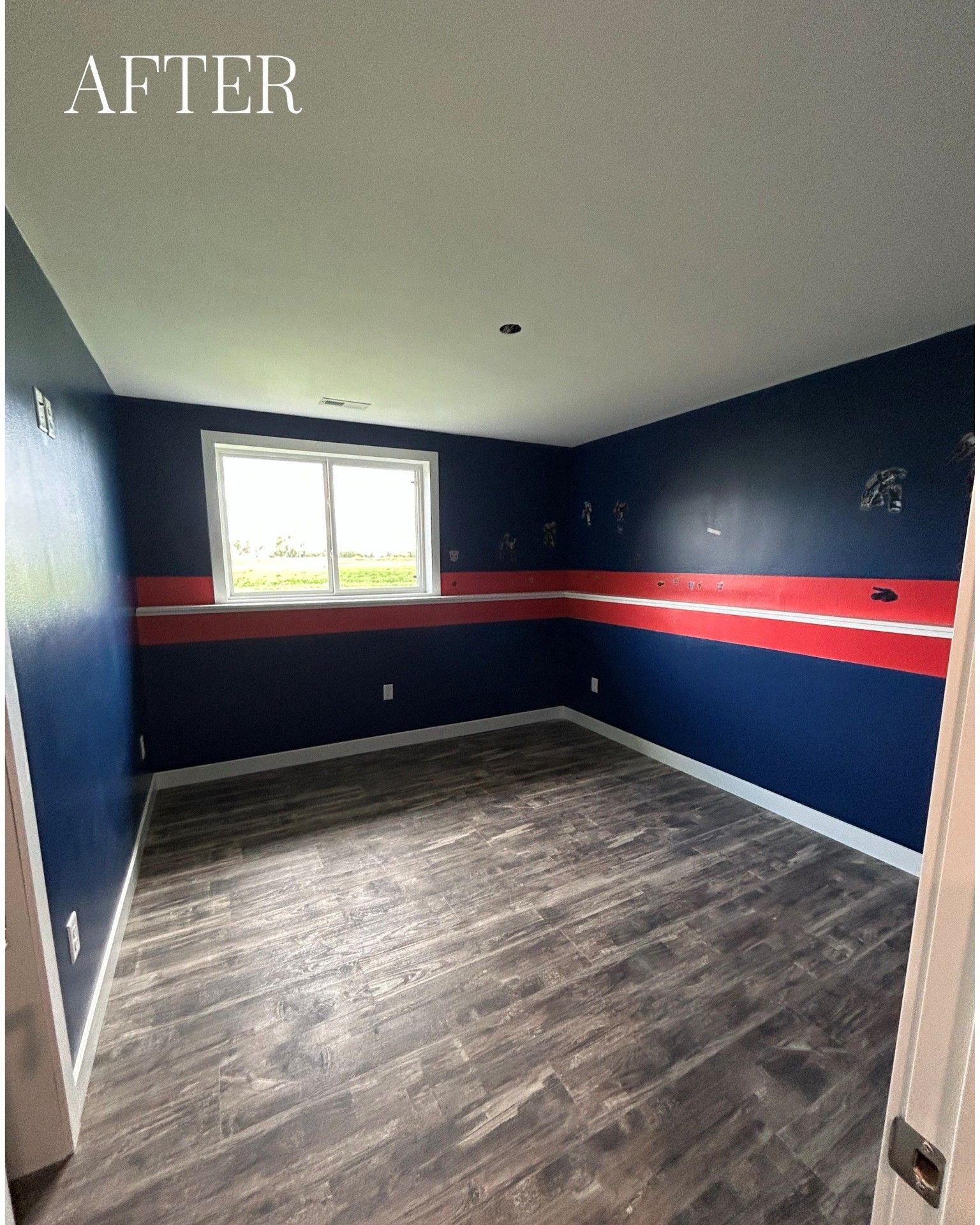 Blue and red painted room with white trim, a window, and dark wood-look flooring.