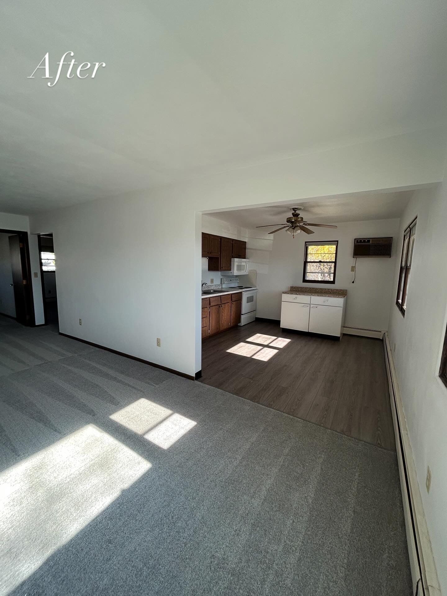 Open concept apartment interior with new flooring and kitchen, natural light.