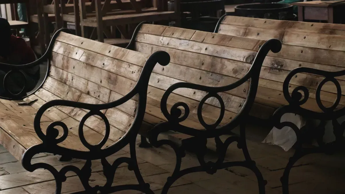Rustic wood table and bench set in a workshop with shelves and tools in the background