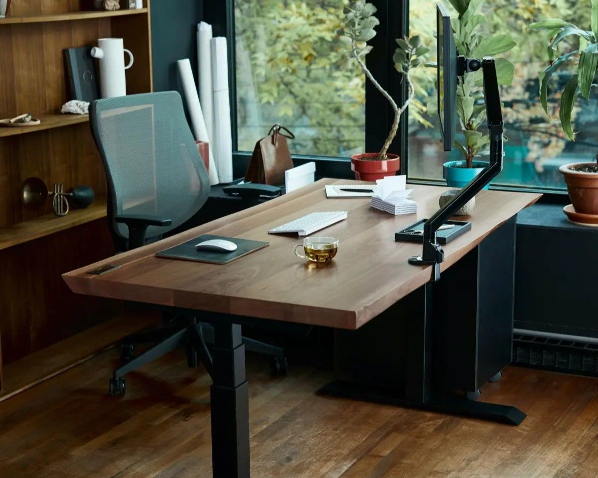 Rustic wood table and bench set in a workshop with shelves and tools in the background