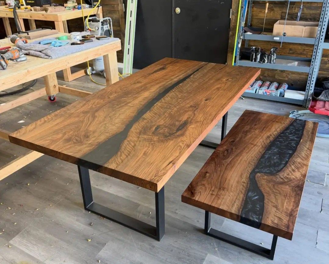 Wood-and-metal tables in a workshop, one large and one small, both with live-edge wood tops.