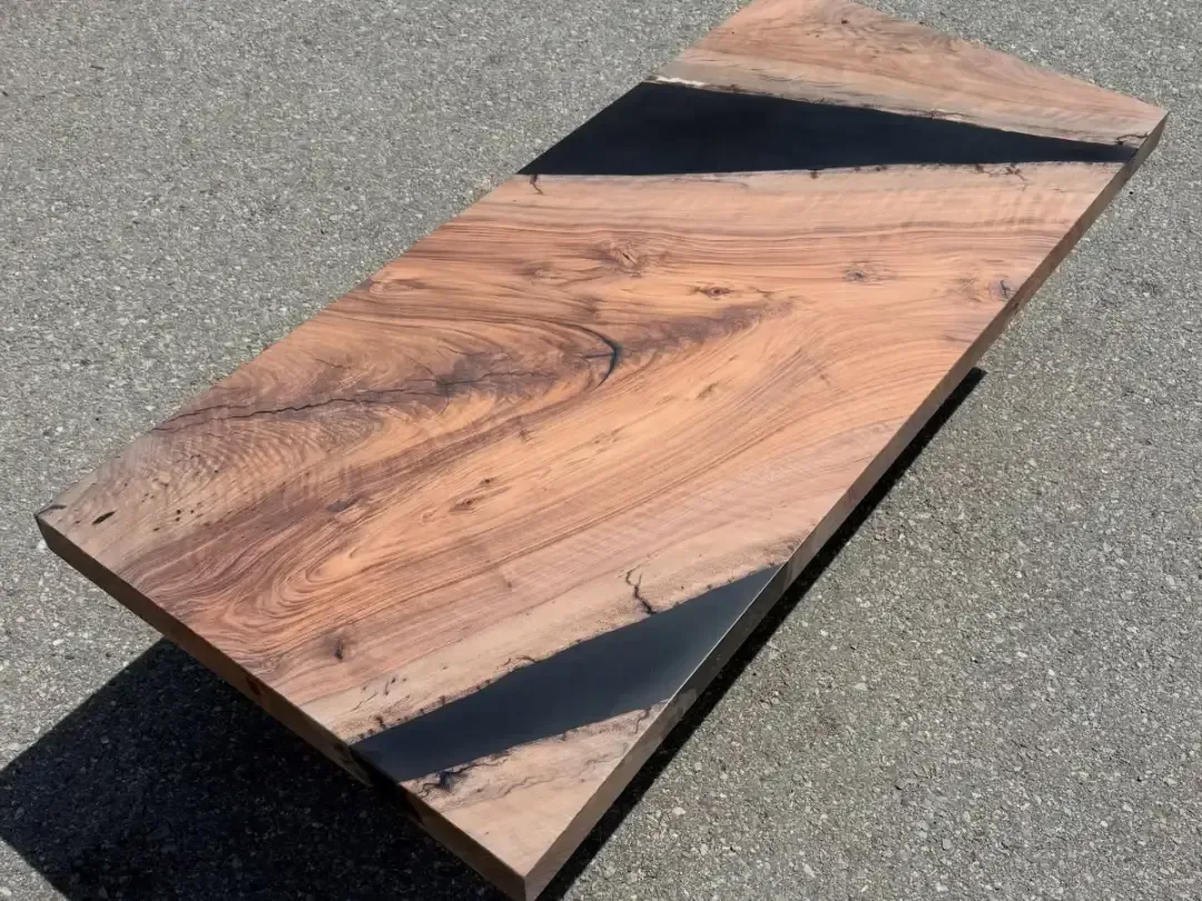Wooden plank with black triangular accents lying on pavement