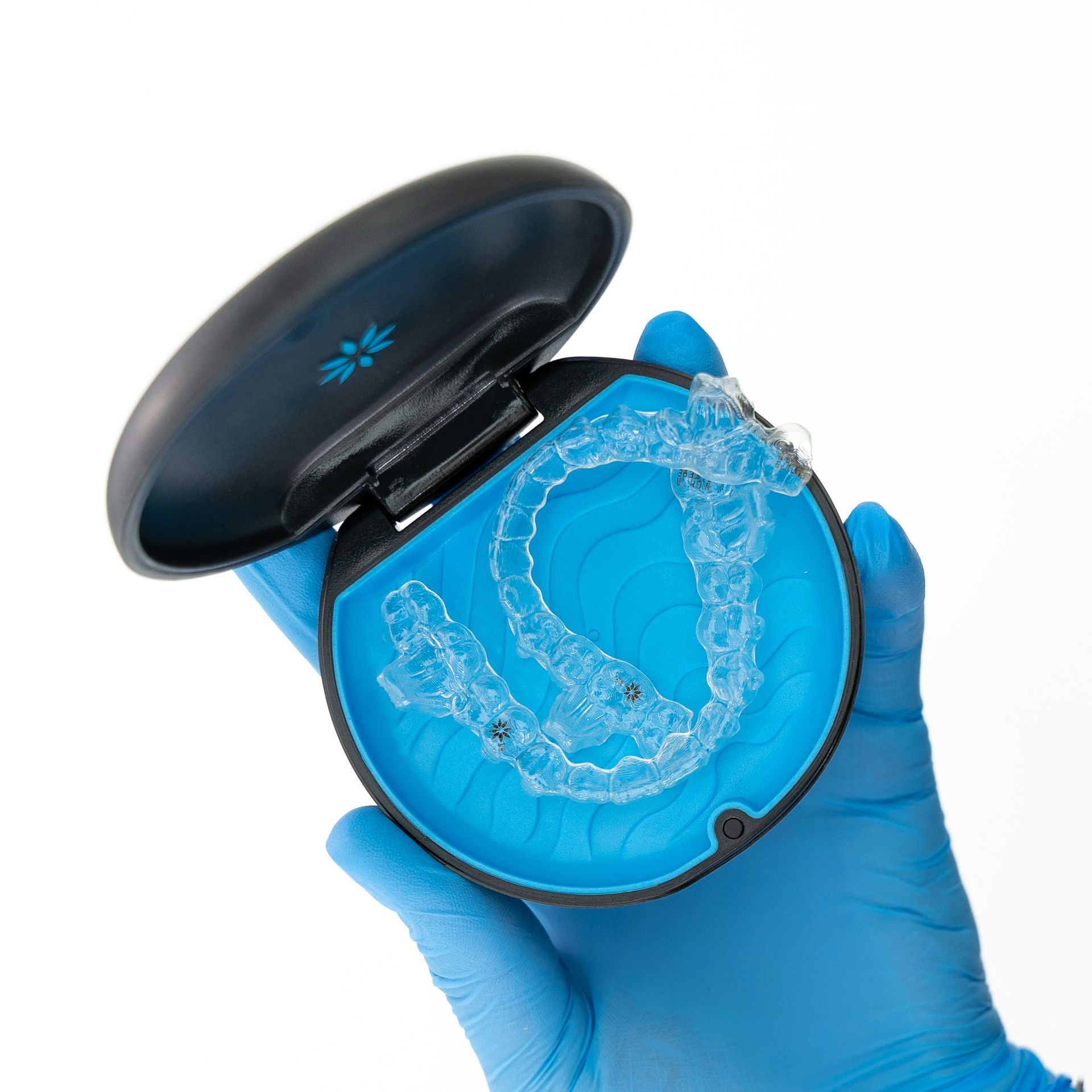 A person wearing blue gloves is holding a case with a clear brace in it.