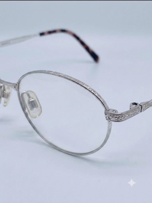 Montatura per occhiali da vista SEIKO in titanio color argento con lenti trasparenti su sfondo bianco.