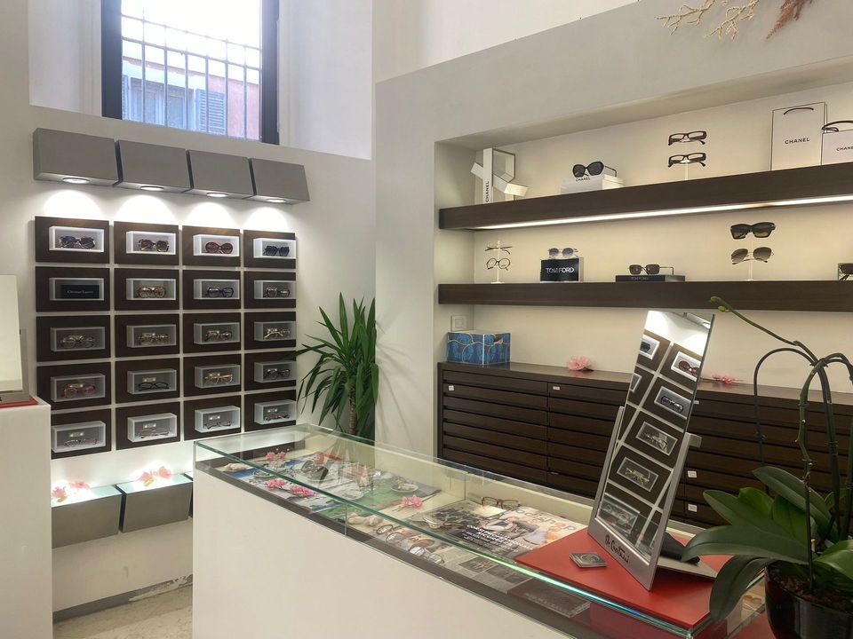 Esposizione di una boutique di lusso con poster di Chanel, scaffali per profumi e insegne di moda all'interno di un negozio.