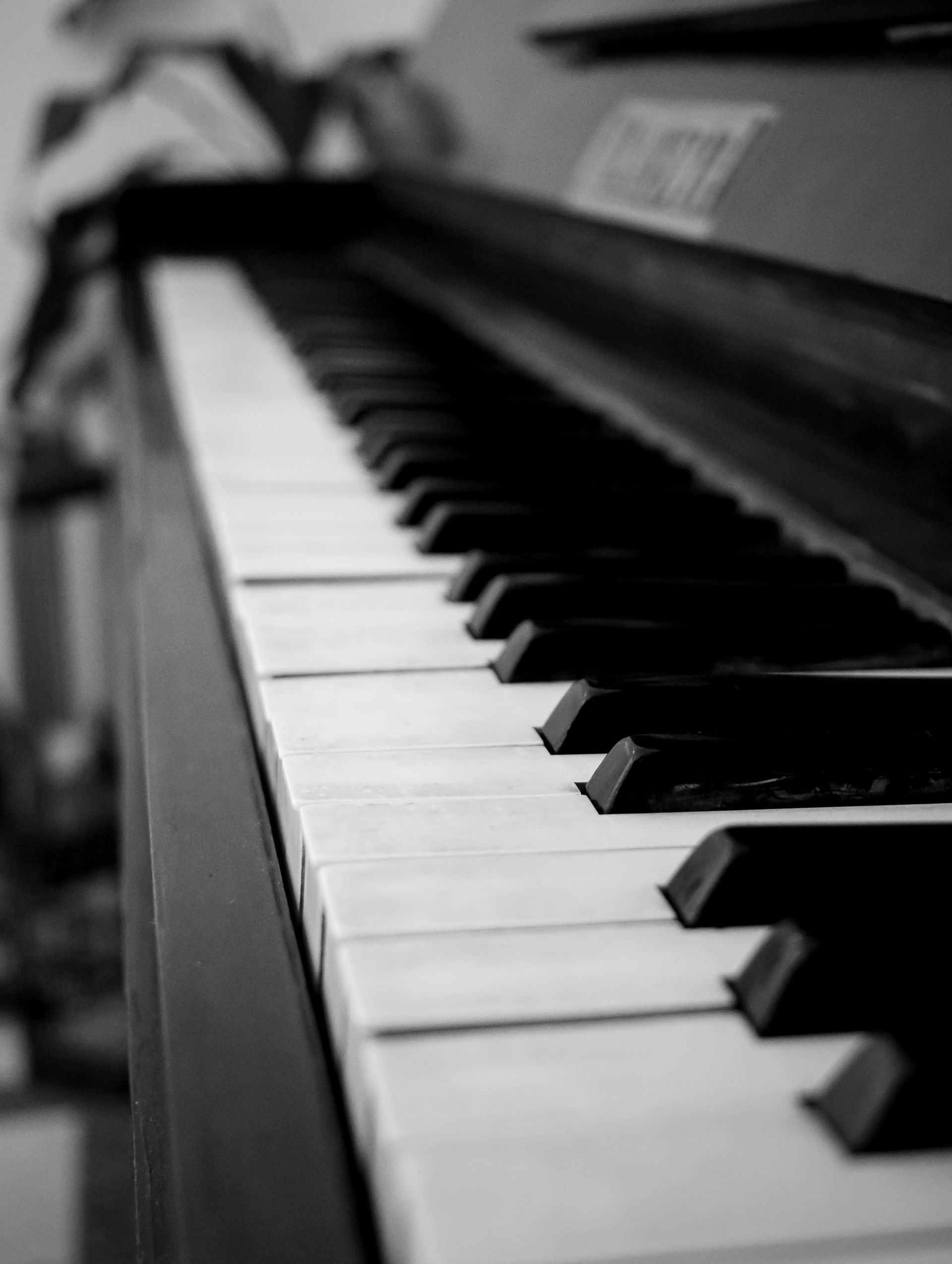Black-and-white close-up of piano keys on a keyboard, viewed at an angle