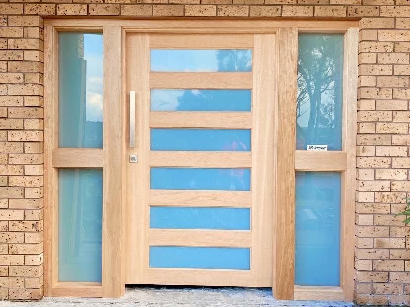 Wooden Front Door with Horizontal Glass Panes and Side Windows Set in Brick — Master Glass & Glazing in Lake Macquarie, NSW