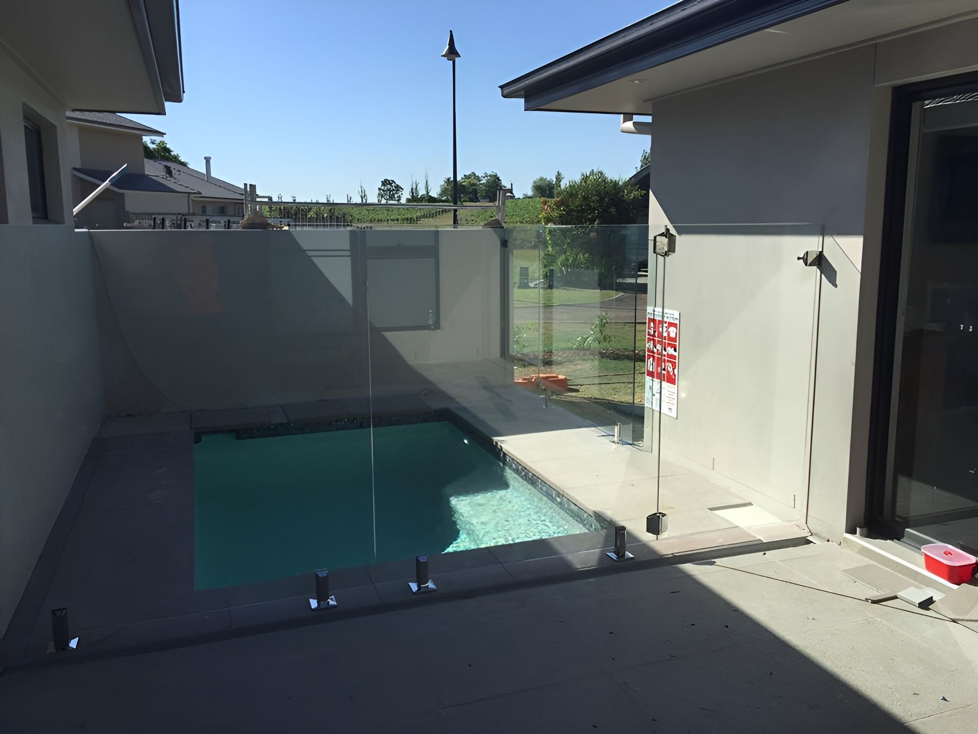 Small Outdoor Pool Enclosed by Glass Panels — Master Glass & Glazing in Mayfield, NSW