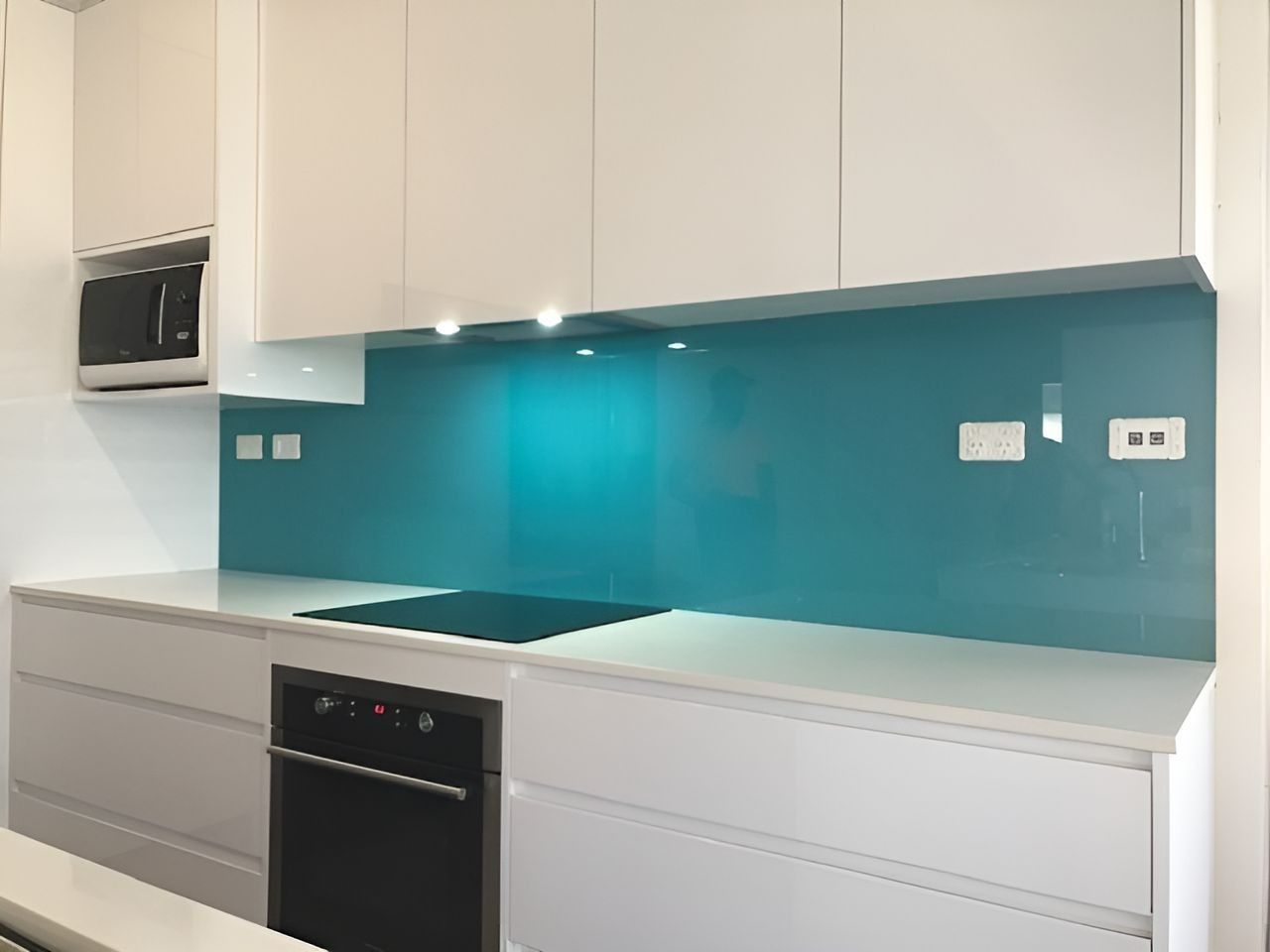 White Kitchen with Teal Backsplash, Cabinets, Oven, and Microwave — Master Glass & Glazing in Newcastle, NSW