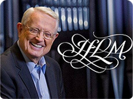 Smiling man in a suit beside an elegant “JLM” logo against dark drapes