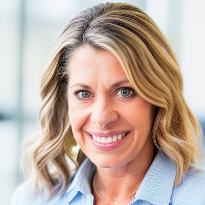 Woman with blonde hair, smiling, in a light blue collared shirt.