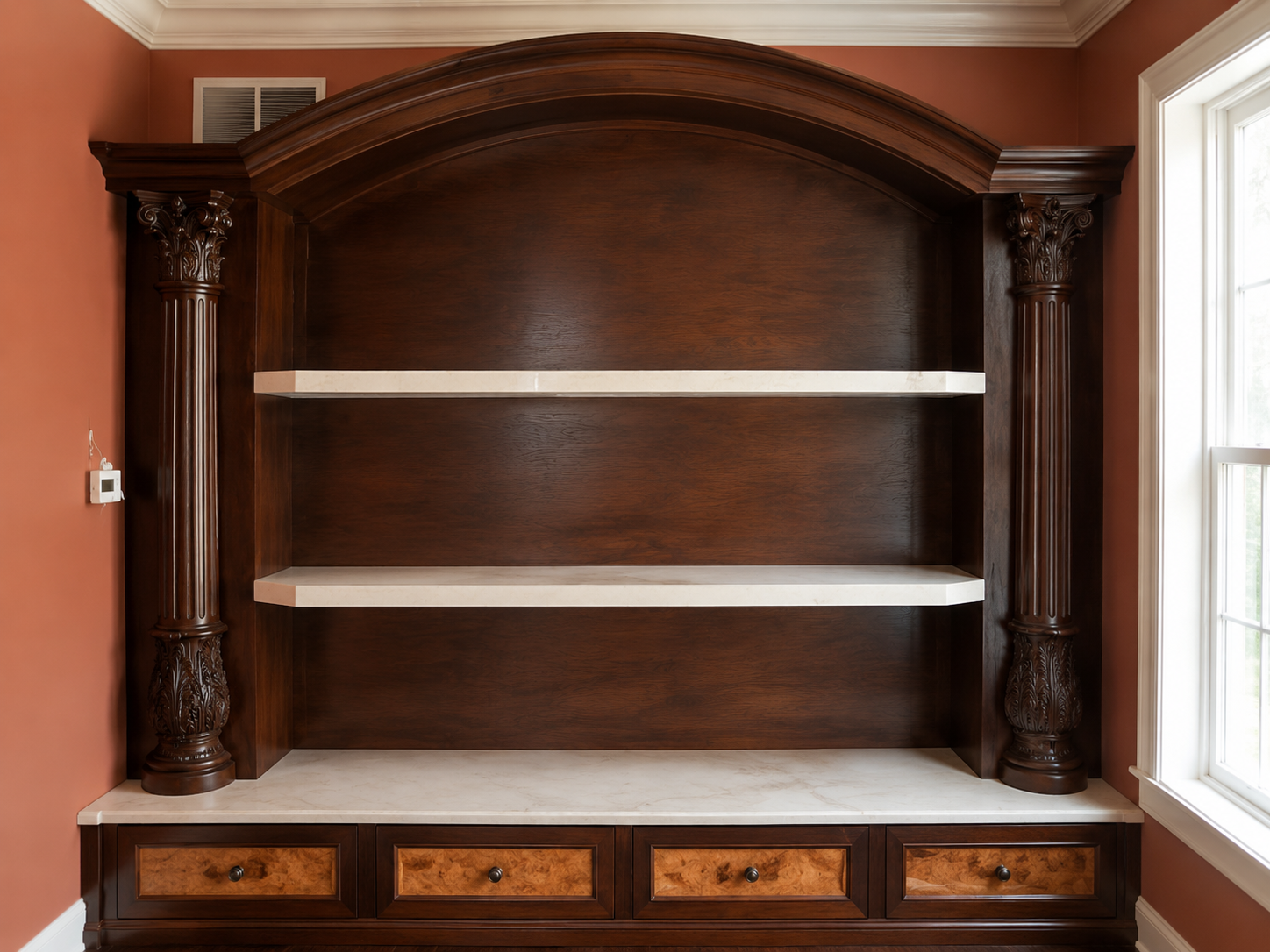 Dark wooden built-in shelving unit with two white shelves and drawers in a room by a window