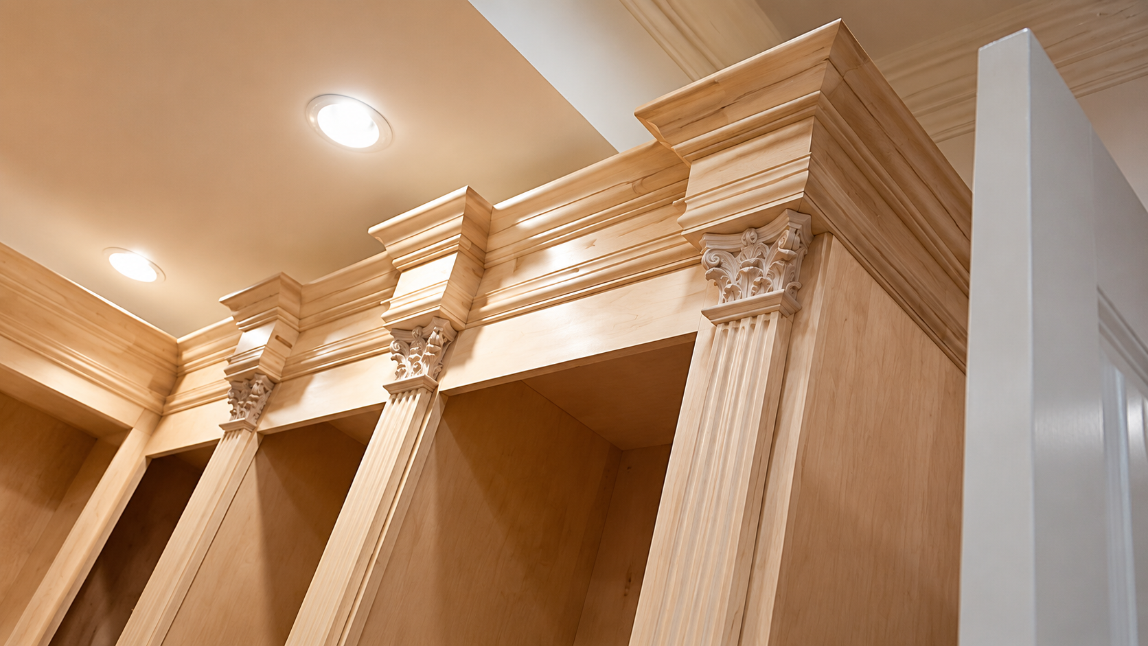 Ornate wooden cabinetry with carved crown molding beneath a ceiling light in a warm-toned interior