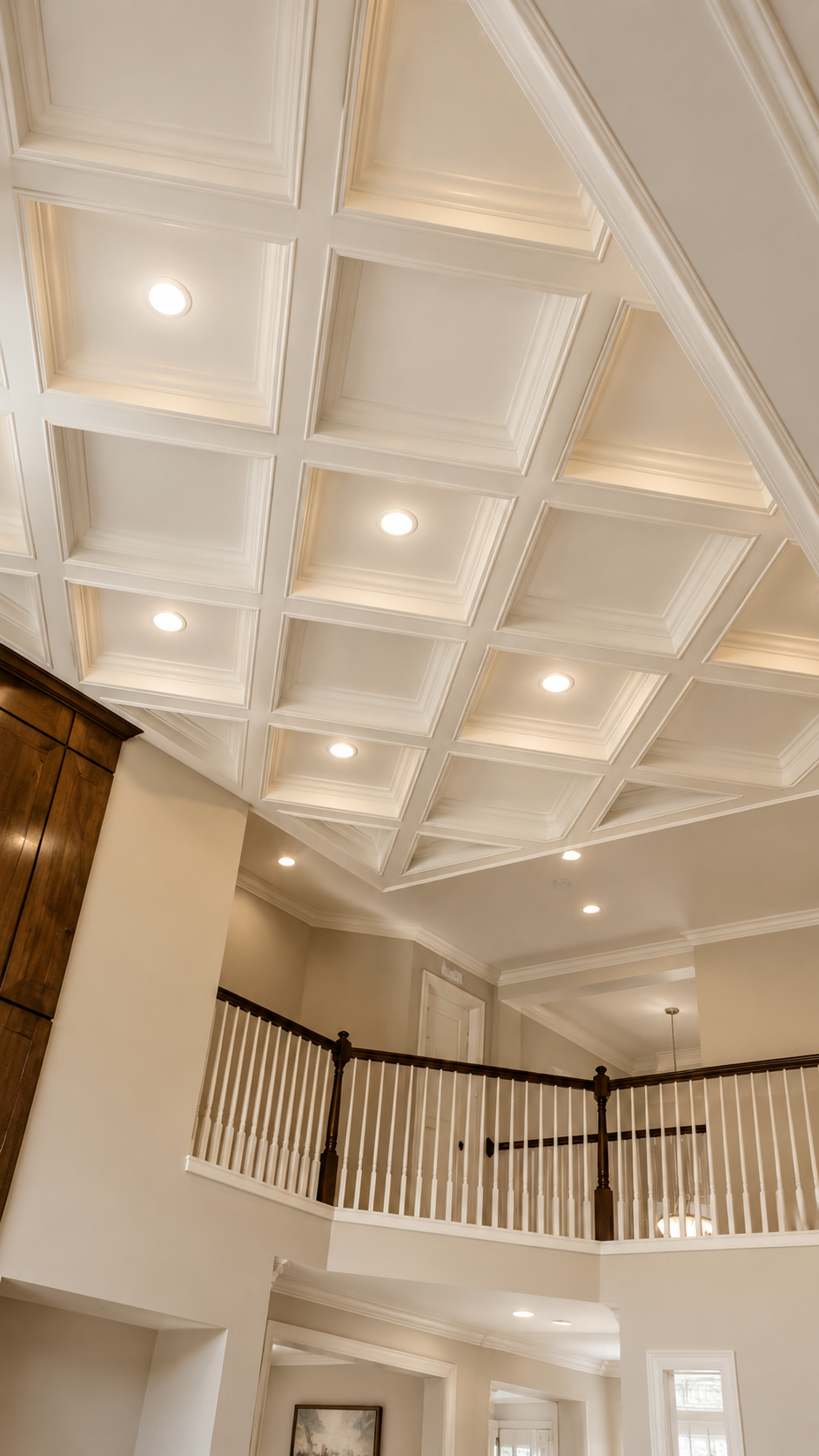 Elegant interior with coffered ceiling, recessed lights, and a curved balcony railing