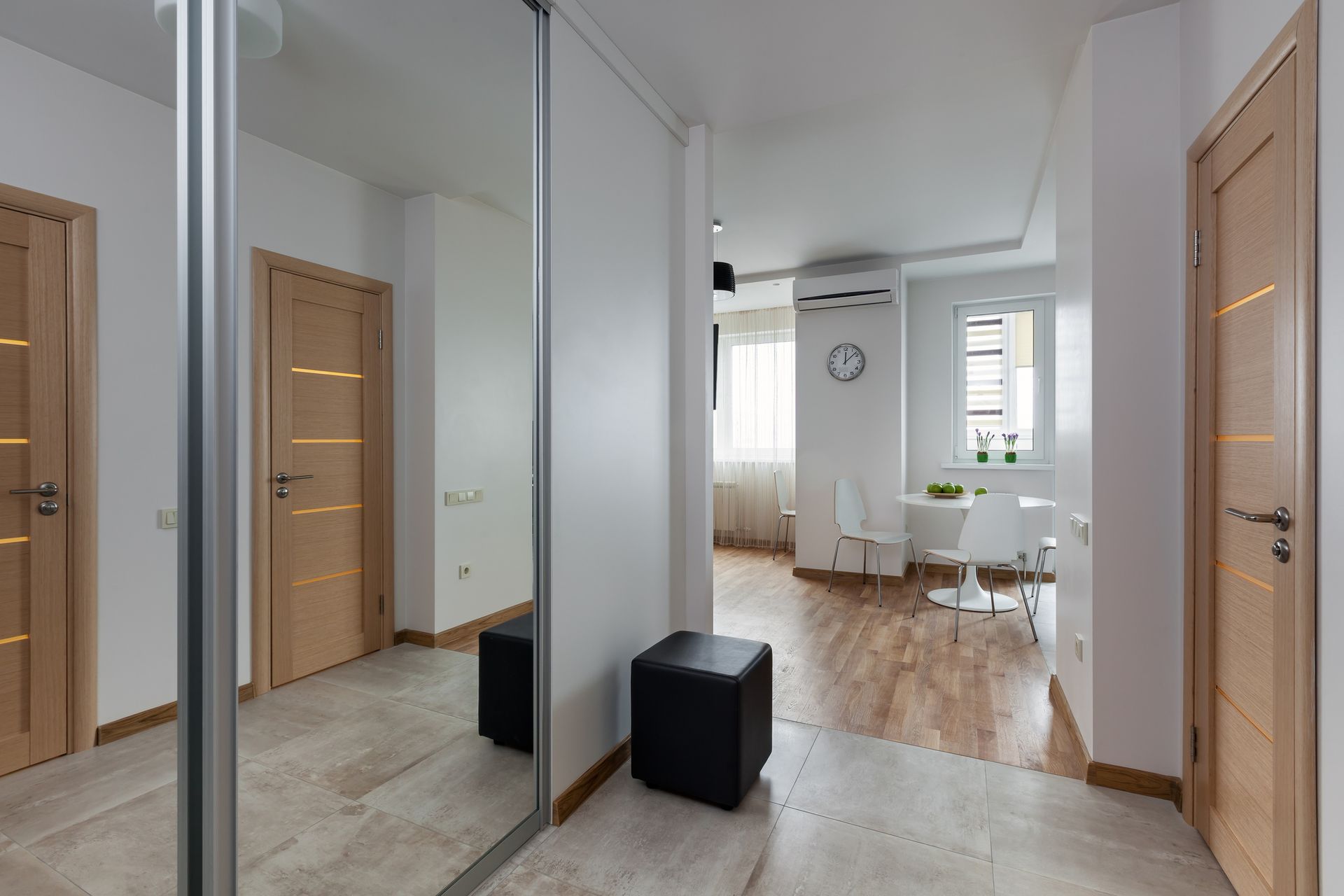 Home gym with a large mirror, weight bench, barbell, weights, and two people.