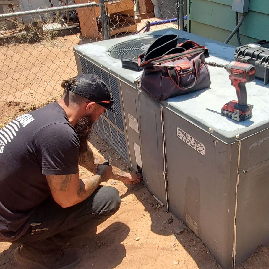 A Thompson Heating and Cooling technician with a beard is working on an air conditioner outside