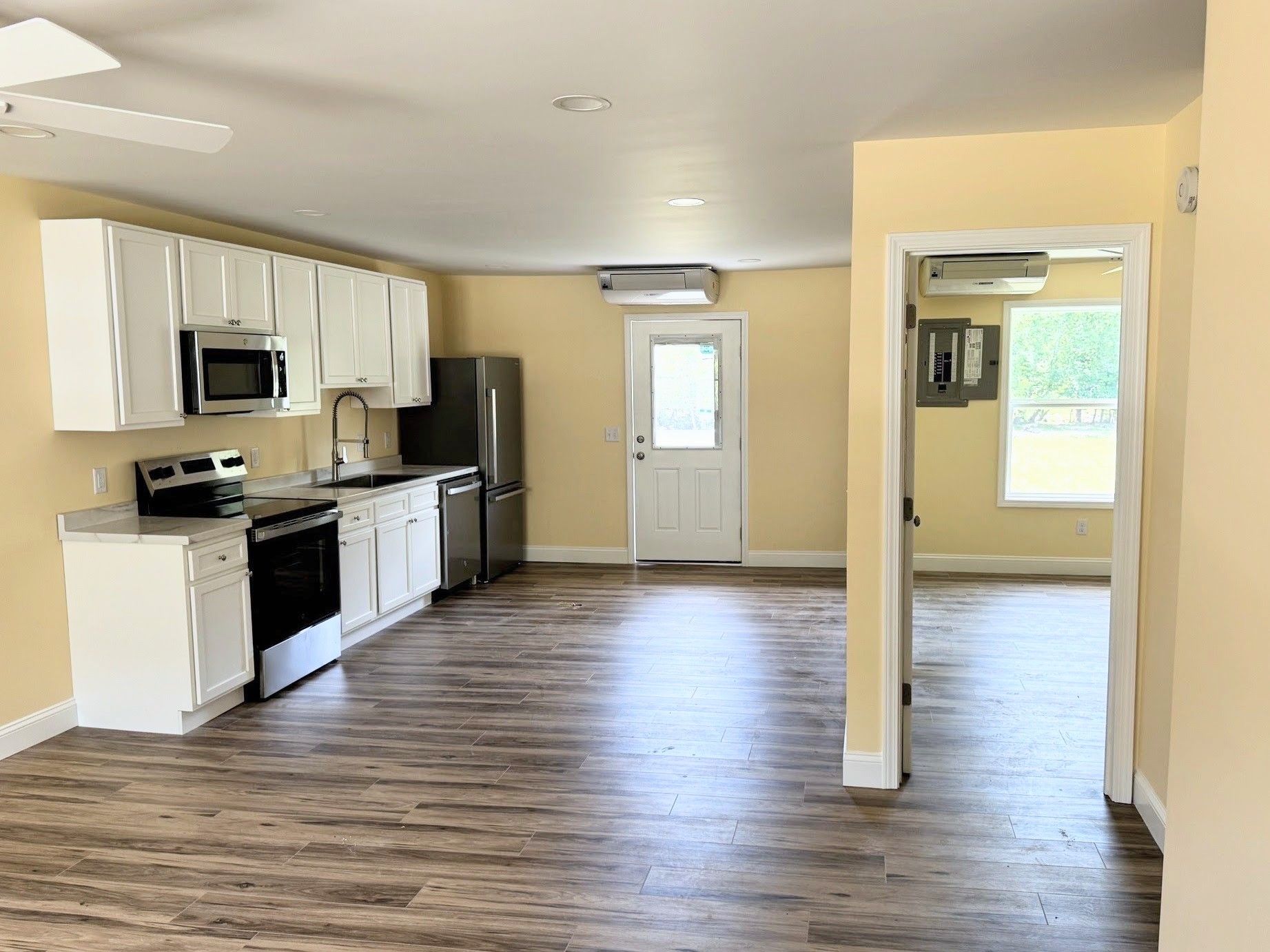 Open-concept kitchen and living area with custom cabinets and luxury vinyl plank flooring