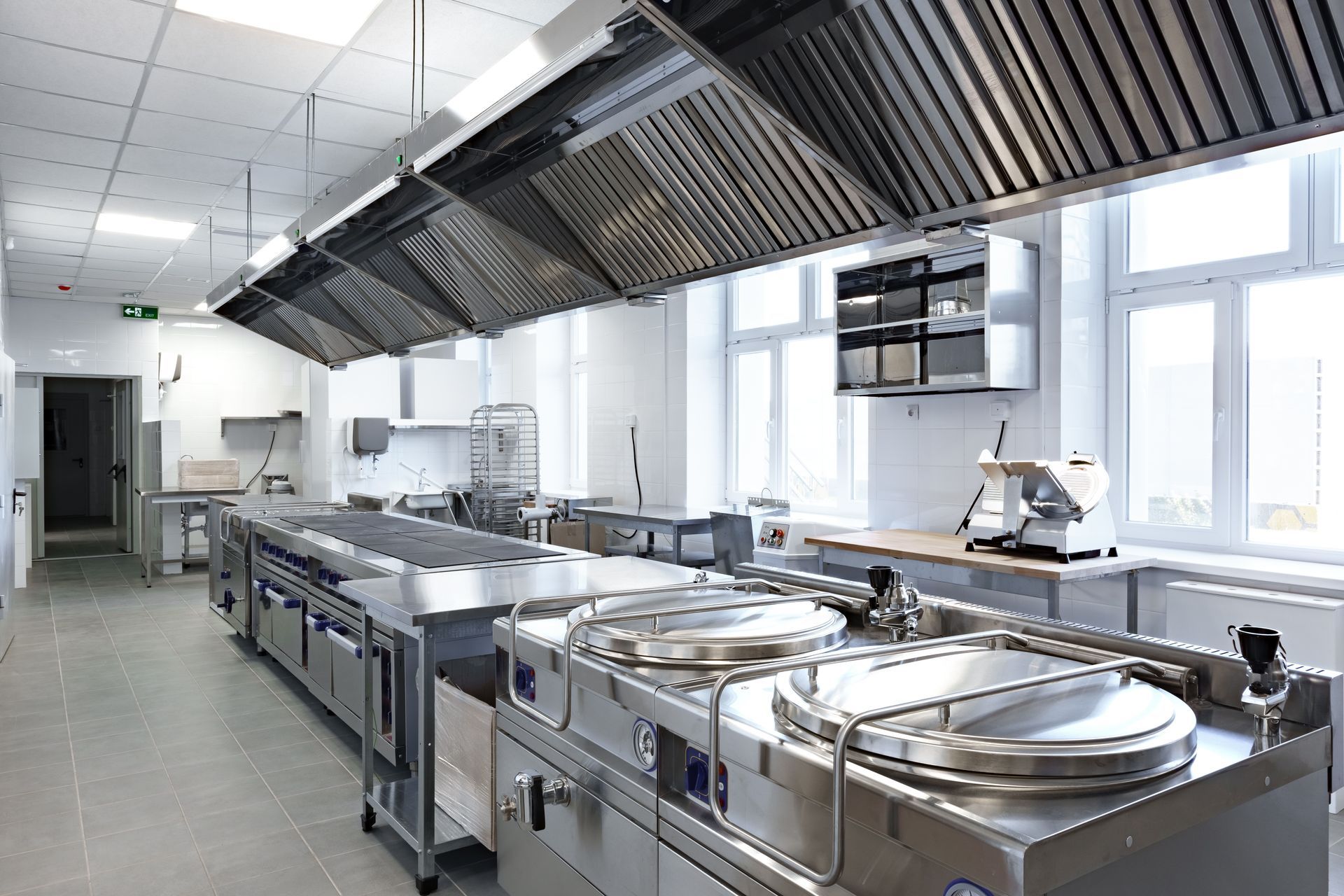 A modern commercial kitchen featuring stainless steel equipment and ample workspace.