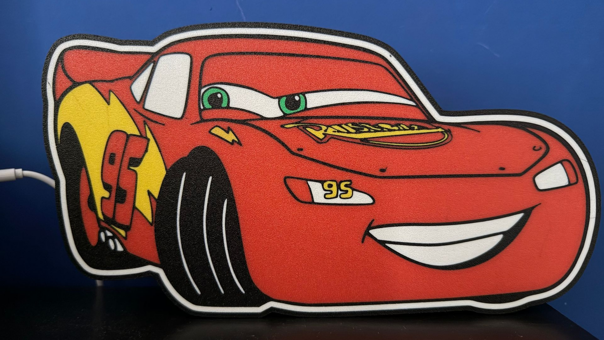Rode cartoon raceauto met een lachend gezicht op een donkere achtergrond